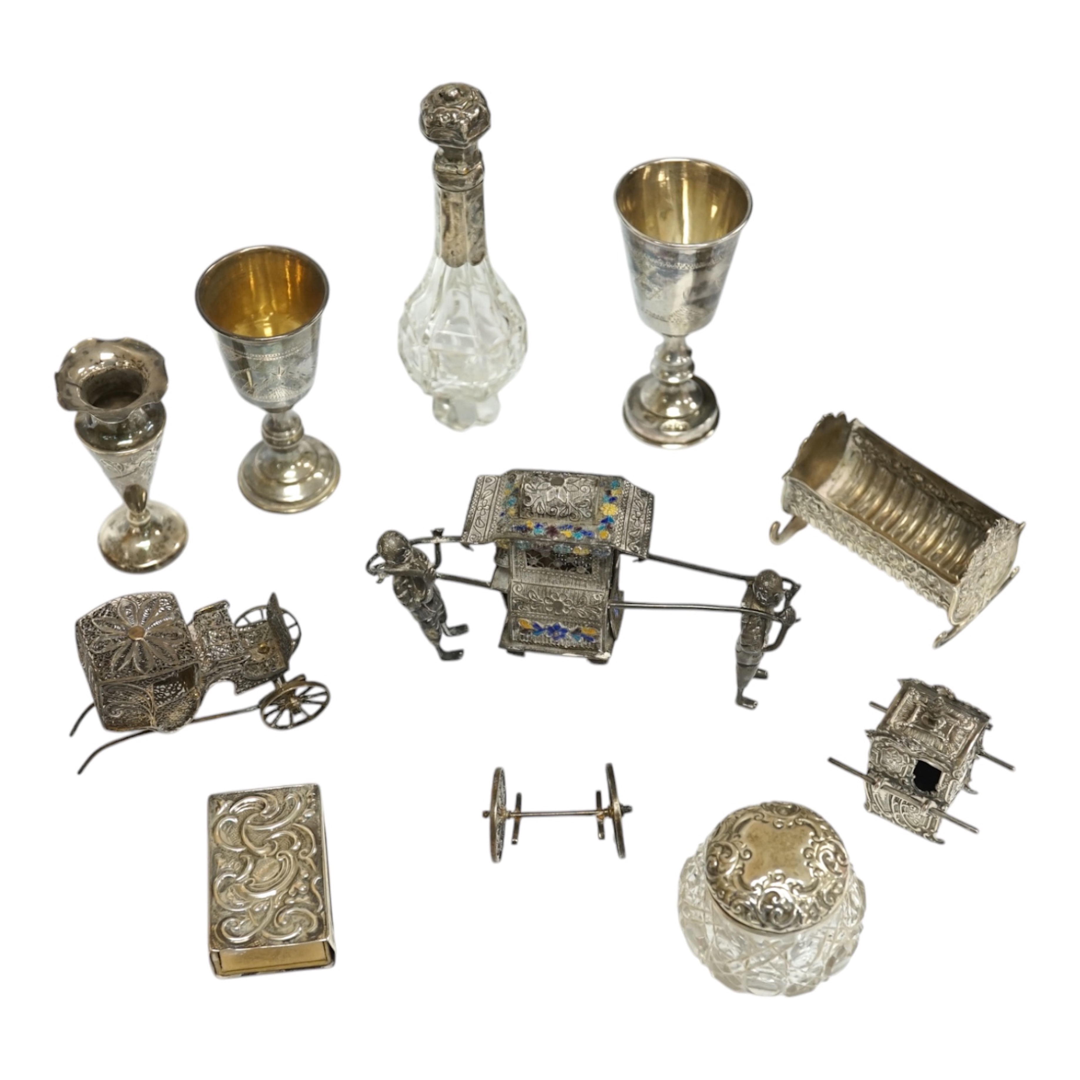 A small collection of miniature silver and white metal items including a cot by Saunders & Shepherd, Birmingham, 1896, 57mm, two filigree items, two Kiddush cups etc. Condition - poor to fair